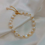 Pulsera retro blanca con perlas y detalles dorados